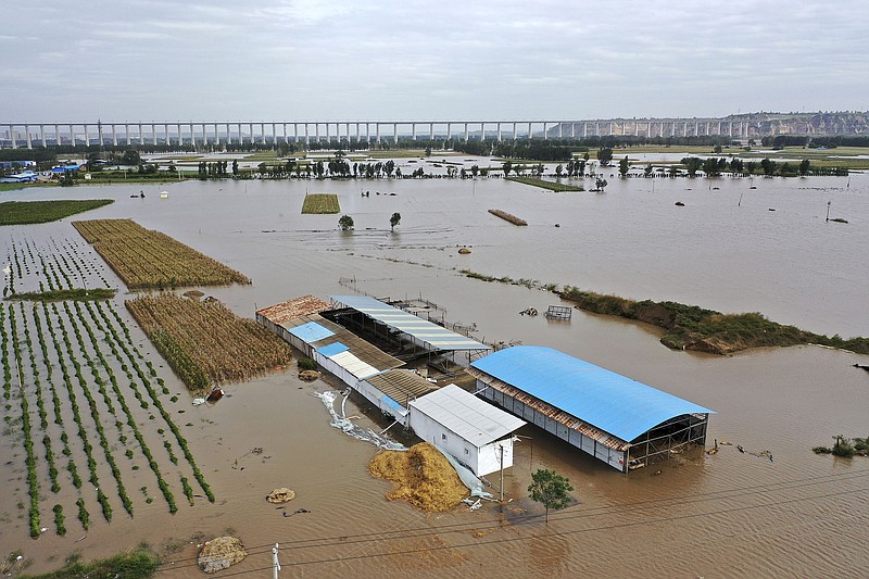 In this photo released by Xinhua News Agency, an aerial photo shows an overflowing Yellow River near the Lianbo Village in Hejin City, northern China's Shanxi Province, Sunday, Oct. 10, 2021. (Zhan Yan/Xinhua via AP)