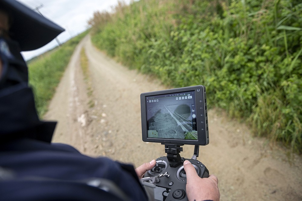 FILE - In this Friday, May 21, 2021 file photo, police drone operator Thanassis Kyriakidis pilots a drone during a patrol at Evros river, near the village of Feres, at the Greek -Turkish border, Greece. Greece will further increase a border guard at its frontier with Turkey, fearing an upcoming spike in attempted illegal migration, officials said Monday, Oct. 11, 2021. (AP Photo/Giannis Papanikos, File)