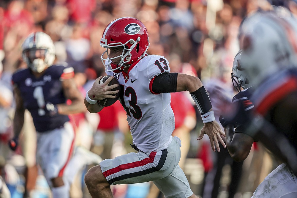 Georgia quarterback Stetson Bennett (13) carries the ball for a first down against Auburn during the second half of an NCAA college football game Saturday, Oct. 9, 2021, in Auburn, Ala. (AP Photo/Butch Dill)