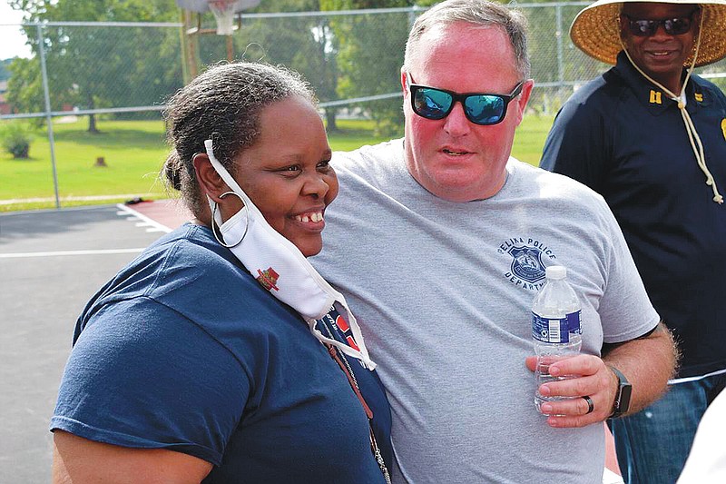 Connye Brooks-Smith, left, stands with Opelika Police Chief Shane Healey at a balloon release in memory of Tramaris Bryant, Tyrone Brooks and Andrew Bryant at the basketball courts of the Covington Recreation Center in Opelika, Ala. In the 20 years following the deaths of Tramaris and Brooks, Tramaris&#x2019; youngest brother Andrew &#x201c;Drew&#x201d; Bryant was also shot and killed in an unsolved homicide in 2005. (Alex Hosey/Opelika-Auburn News via AP)