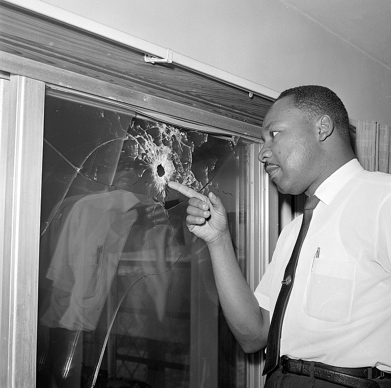 FILE - In this June 5, 1964, file photo, Dr. Martin Luther King Jr. looks at a glass door of his rented beach cottage in St. Augustine, Fla., that was shot into. The house connected to King  is now in the hands of a couple who plans to preserve it. David Manaute and Patti Barry live in the house on the coastline south of St. Augustine.  (AP Photo/Jim Kerlin, File)
