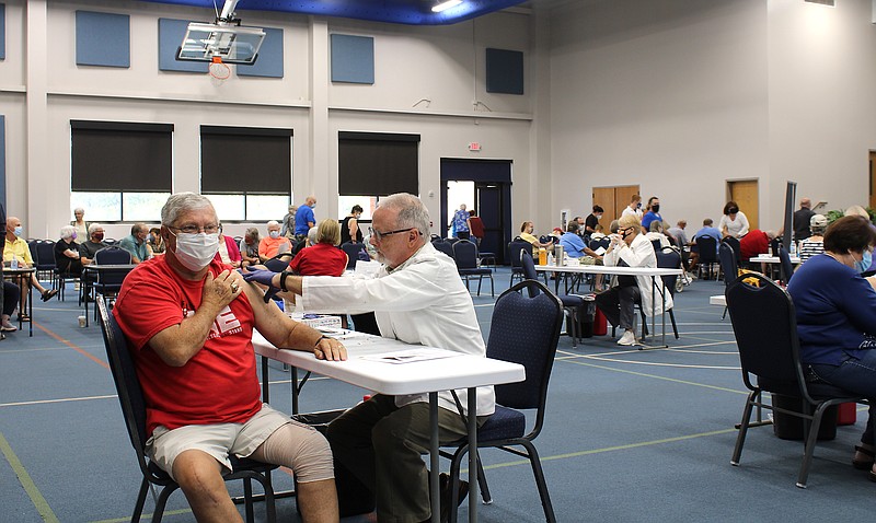 Health officials administer flu shots Tuesday during a mass vaccination clinic at Balboa Baptist Church in Hot Springs Village. - Photo by J.P. Ford of The Sentinel-Record