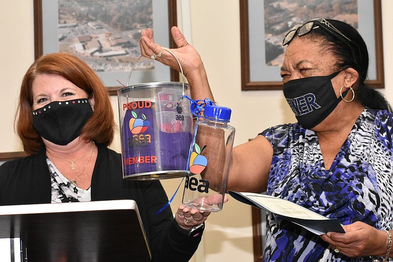 Carol Fleming, president of the Arkansas Education Association, presents goodies and a certificate to Watson Chapel High School teacher Frankie Hemphill during the district board meeting Monday, Oct. 11, 2021. (Pine Bluff Commercial/I.C. Murrell)