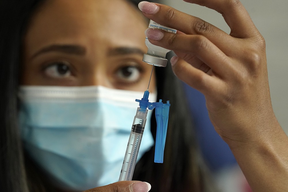 FILE - In this May 19, 2021, file photo, a licensed practical nurse draws a Moderna COVID-19 vaccine into a syringe at a mass vaccination clinic at Gillette Stadium in Foxborough, Mass. Starting Thursday, Oct. 14, 2021, the Food and Drug Administration convenes its independent advisers for the first stage in the process of deciding whether extra shots of Moderna or Johnson & Johnson vaccines should be dispensed and, if so, who should get them and when. (AP Photo/Steven Senne, File)