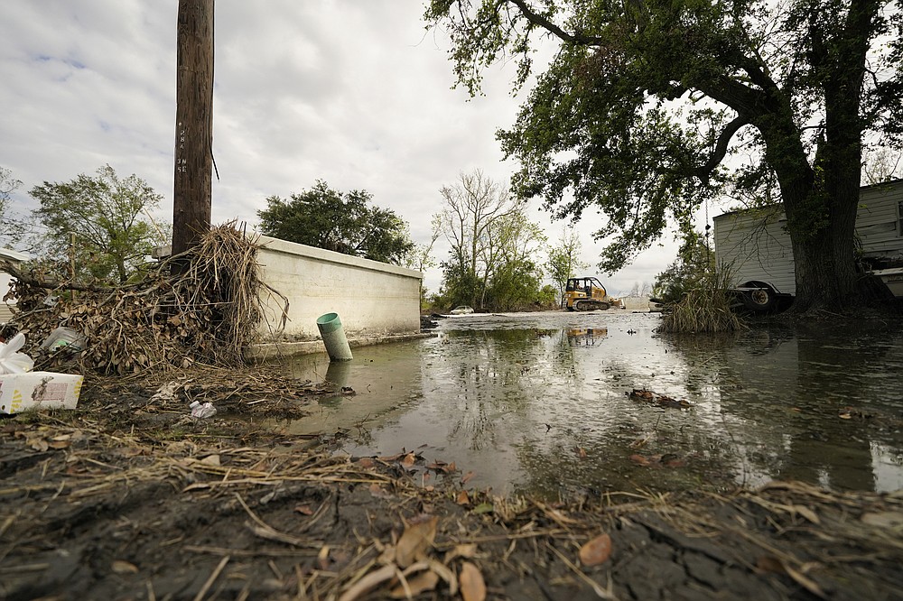 A bulldozer repairs a cemetery damaged from Hurricane Ida in Ironton, La., Monday, Sept. 27, 2021. A Louisiana task force is working to gather vaults and caskets disrupted from their burial sites by Hurricane Ida and rebury them. (AP Photo/Gerald Herbert)
