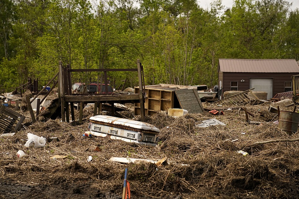 A displaced casket that floated from a cemetery during flooding from Hurricane Ida, sits among displaced marsh grass and ruin, in Ironton, La., Monday, Sept. 27, 2021. Hurricane Ida swept through Louisiana with furious winds that ripped roofs off buildings and storm surge so powerful it moved homes. And what it wrought on the living it also wrought on the dead, moving vaults and caskets and adding another layer of trauma on families and communities recovering from the powerful storm. (AP Photo/Gerald Herbert)