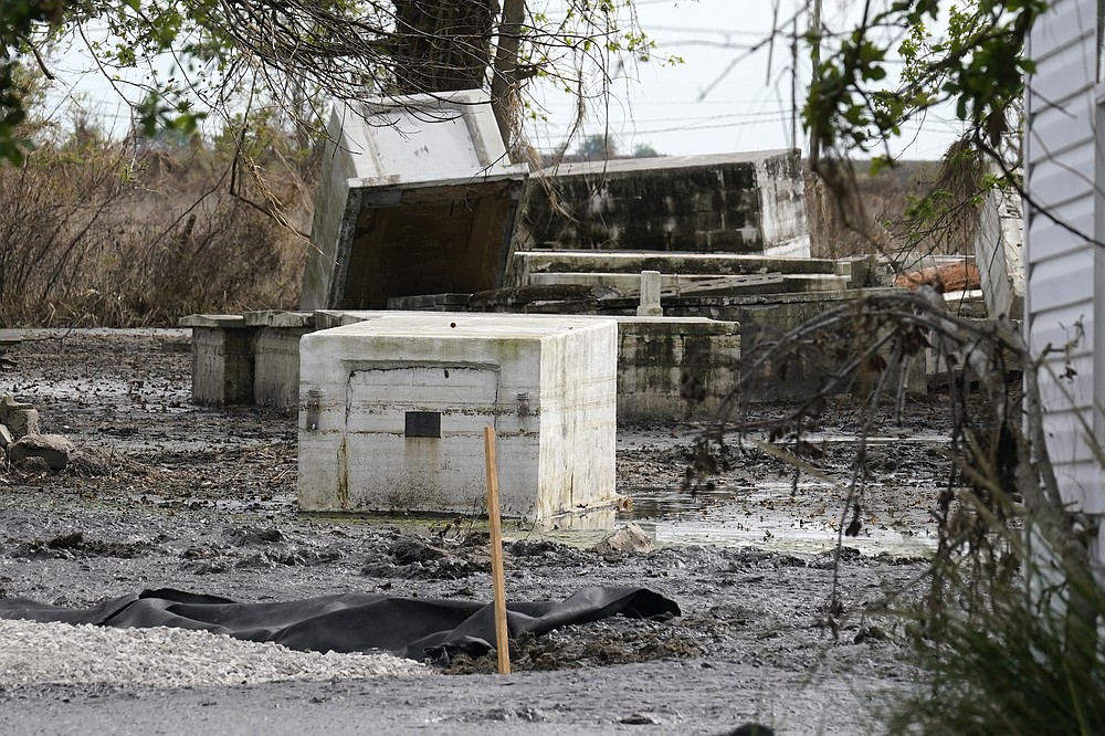 Tombs damaged from flooding from Hurricane Ida sit atop one another in Ironton, La., Monday, Sept. 27, 2021. Hurricane Ida swept through Louisiana with furious winds that ripped roofs off buildings and storm surge so powerful it moved homes. And what it wrought on the living it also wrought on the dead, moving vaults and caskets and adding another layer of trauma on families and communities recovering from the powerful storm. (AP Photo/Gerald Herbert)