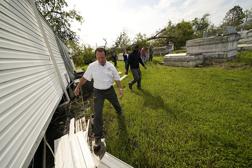Louisiana Attorney General Jeff Landry walks through a cemetery during a survey after Hurricane Ida, in LaPlace, La., Wednesday, Sept. 22, 2021. A Louisiana task force is working to gather vaults and caskets disrupted from their burial sites by Hurricane Ida and rebury them. (AP Photo/Gerald Herbert)