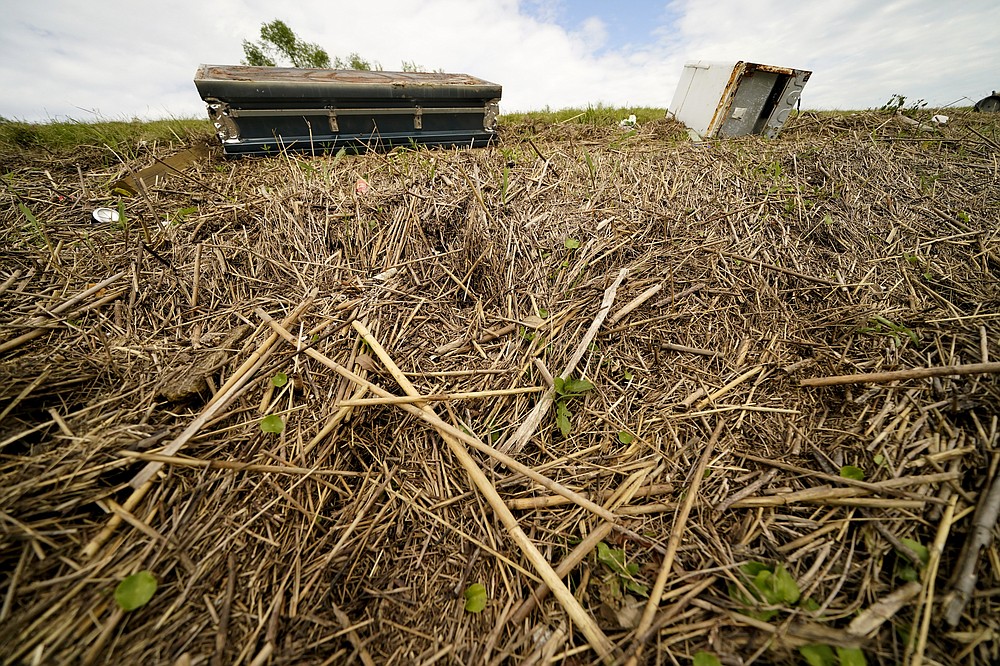 A displaced casket that floated from a cemetery during flooding from Hurricane Ida, sits near displaced marsh grass, on the Mississippi River levee in Ironton, La., Monday, Sept. 27, 2021. Hurricane Ida swept through Louisiana with furious winds that ripped roofs off buildings and storm surge so powerful it moved homes. And what it wrought on the living it also wrought on the dead, moving vaults and caskets and adding another layer of trauma on families and communities recovering from the powerful storm. (AP Photo/Gerald Herbert)