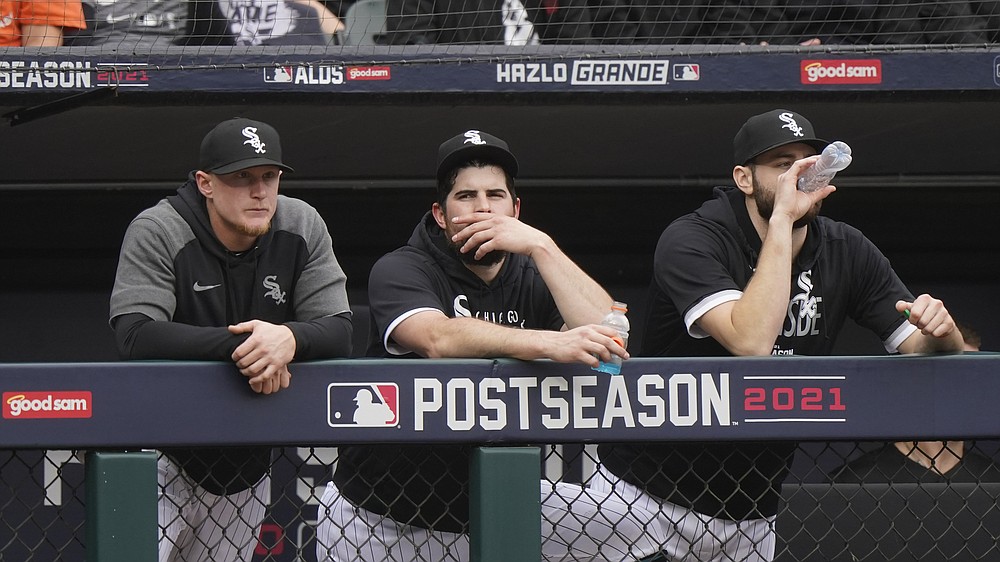 Chicago White Sox pitcher Carlos Rodon, center, watches from the dugout with Andrew Vaughn, left, and Lucas Giolito against the Houston Astros in the third inning during Game 4 of a baseball American League Division Series Tuesday, Oct. 12, 2021, in Chicago. (AP Photo/Nam Y. Huh)
