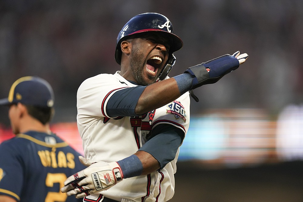 Atlanta Braves' Guillermo Heredia (38) celebrates an two RBI single hit by Atlanta Braves' Eddie Rosario during the fourth inning of Game 4 of a baseball National League Division Series against the Milwaukee Brewers, Tuesday, Oct. 12, 2021, in Atlanta. (AP Photo/Brynn Anderson)