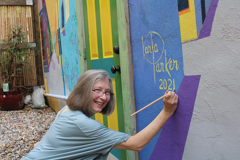 Artist Karla Parker signs her mural at the Argentinian Coffee & Wine Bar on Wednesday. - Photo by J.P. Ford of The Sentinel-Record