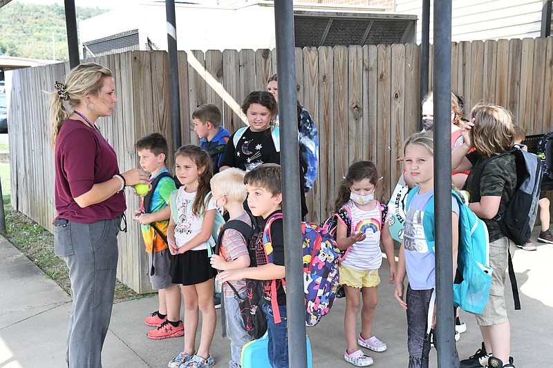 Teacher Rebekah Dixon stands with Cutter Morning Star students as they wait to be picked up on Wednesday. - Photo by Tanner Newton of The Sentinel-Record
