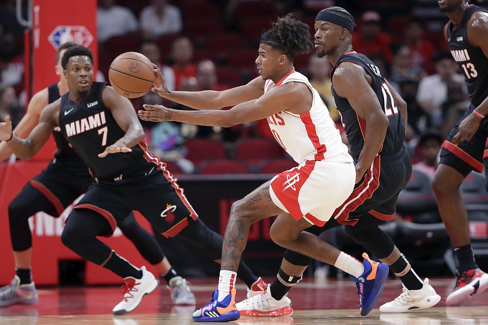 Houston Rockets guard Jalen Green, center, passes the ball between Miami Heat guard Kyle Lowry (7) and forward Jimmy Butler, right, during the first half of an NBA preseason basketball game Thursday, Oct. 7, 2021, in Houston. (AP Photo/Michael Wyke)