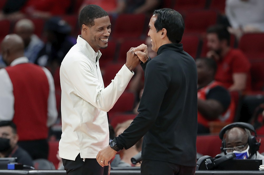 Houston Rockets coach Stephen Silas, left, and Miami Heat head coach Erik Spoelstra bump fists after the Heat's 113-106 win in an NBA preseason basketball game Thursday, Oct. 7, 2021, in Houston. (AP Photo/Michael Wyke)