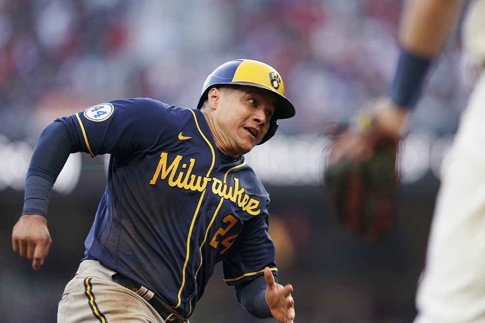 Milwaukee Brewers' Avisail Garcia (24) heads home on an RBI single hit by Milwaukee Brewers Omar Narvaez during the fourth inning of Game 4 of a baseball National League Division Series against the Atlanta Braves, Tuesday, Oct. 12, 2021, in Atlanta. (AP Photo/Brynn Anderson)