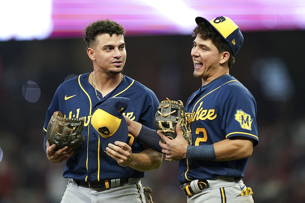 Milwaukee Brewers shortstop Willy Adames, left, speaks with Milwaukee Brewers third baseman Luis Urias during the seventh inning of Game 4 of a baseball National League Division Series against the Atlanta Braves , Tuesday, Oct. 12, 2021, in Atlanta. (AP Photo/Brynn Anderson)