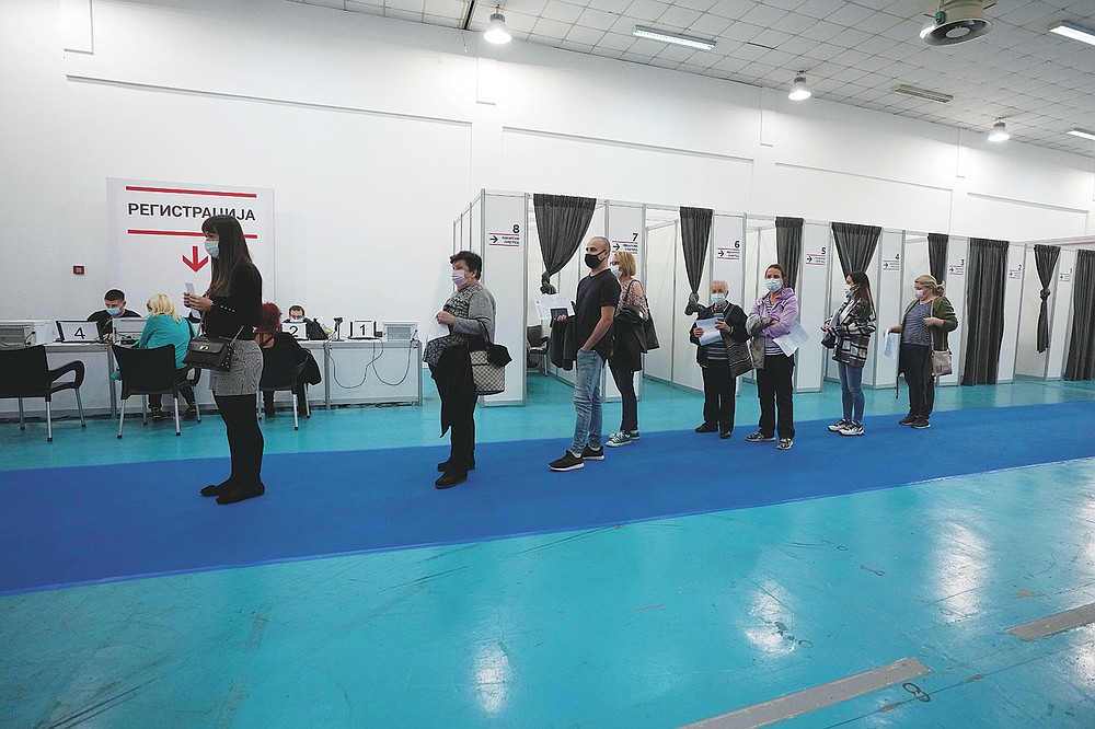 People wait in line to receive a dose of a COVID-19 vaccine at Belgrade Fair makeshift vaccination center in Belgrade, Serbia, Saturday, Oct. 2, 2021. Russians are flocking to Serbia to receive Western-approved COVID-19 shots. Although Russia has its own vaccine known as Sputnik V, the shot has not been approved by international health authorities. (AP Photo/Darko Vojinovic)
