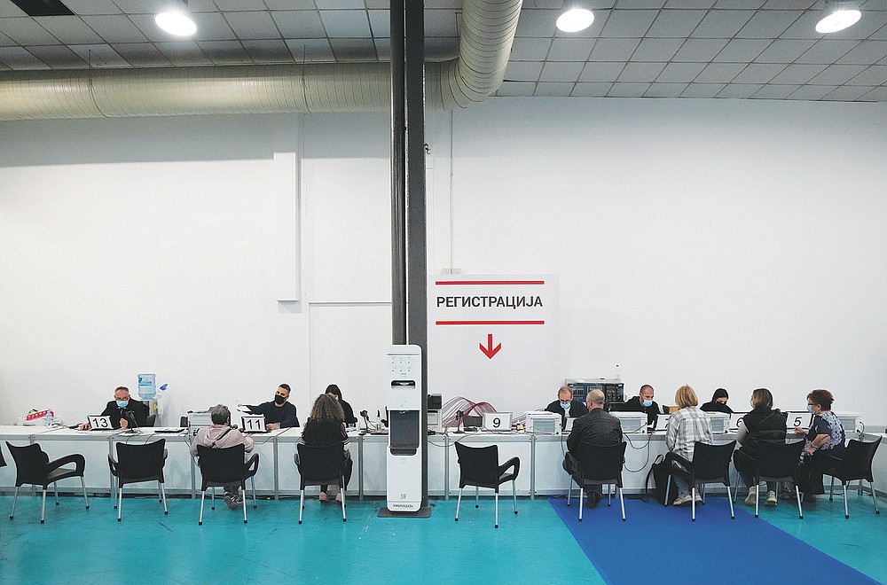 People fill out vaccination consent forms at Belgrade Fair makeshift vaccination center in Belgrade, Serbia, Saturday, Oct. 2, 2021. (AP Photo/Darko Vojinovic)