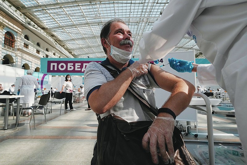 FILE - In this July 12, 2021, file photo, a medical worker administers a shot of Russia's Sputnik V coronavirus vaccine at a vaccination center in Gostinny Dvor, a huge exhibition place in Moscow, Russia. Russians are flocking to Serbia to receive Western-approved COVID-19 shots. Although Russia has its own vaccine known as Sputnik V, the shot has not been approved by international health authorities. (AP Photo/Pavel Golovkin, File)
