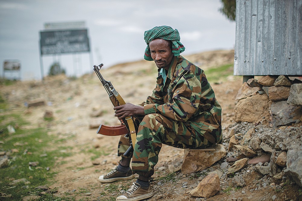 FILE - In this Friday, May 7, 2021 file photo, a fighter loyal to the Tigray People's Liberation Front (TPLF) mans a guard post on the outskirts of the town of Hawzen, then-controlled by the group, in the Tigray region of northern Ethiopia. Tigray forces say Ethiopia&#x2019;s government has launched its threatened major military offensive against them in an attempt to end a nearly year-old war. A statement from the Tigray external affairs office on Monday, Oct. 11 alleged that hundreds of thousands of Ethiopian &#x201c;regular and irregular fighters&#x201d; launched a coordinated assault on several fronts. (AP Photo/Ben Curtis, File)
