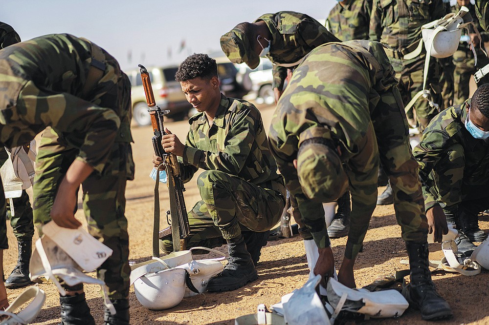 Soldiers from the Polisario Front pack after a National Unity Day event in the Dajla refugee camp, Algeria, Tuesday, Oct. 12, 2021. (AP Photo/Bernat Armangue)