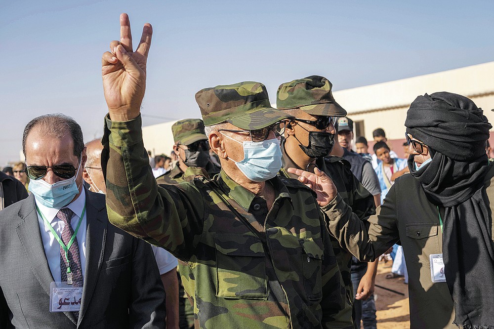 Brahim Ghali, head of the Polisario Front and the self-declared Sahrawi Democratic Arab Republic, gestures the victory sign during a National Unity Day event in the Dajla refugee camp, Algiers, Tuesday, Oct. 12, 2021. (AP Photo/Bernat Armangue)