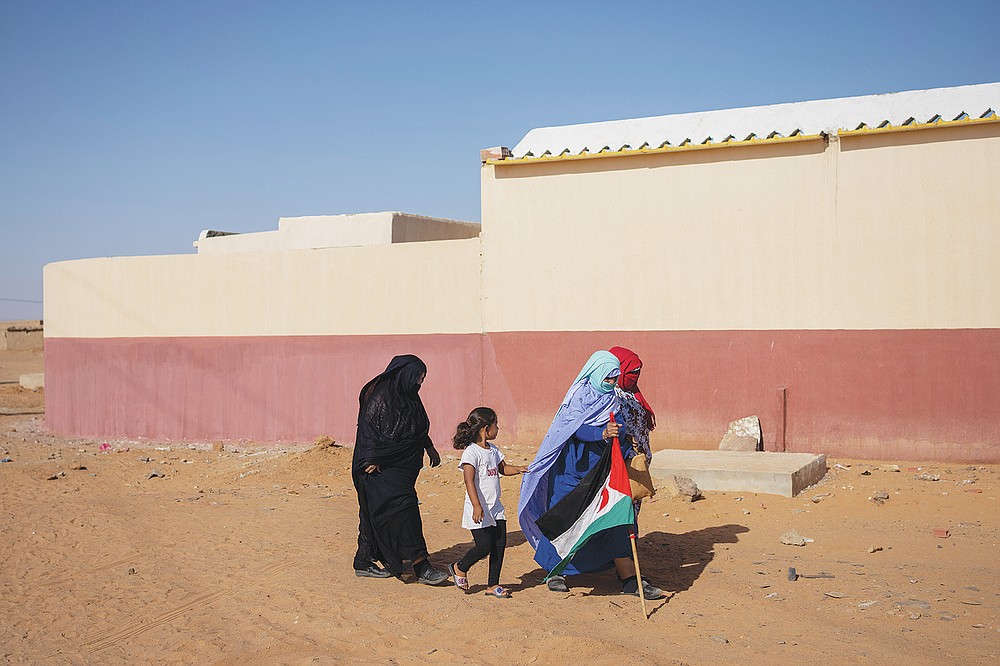 Saharaui refugees walk towards a National Unity Day event in the Dajla refugee camp, Algeria, Tuesday, Oct. 12, 2021. (AP Photo/Bernat Armangue)