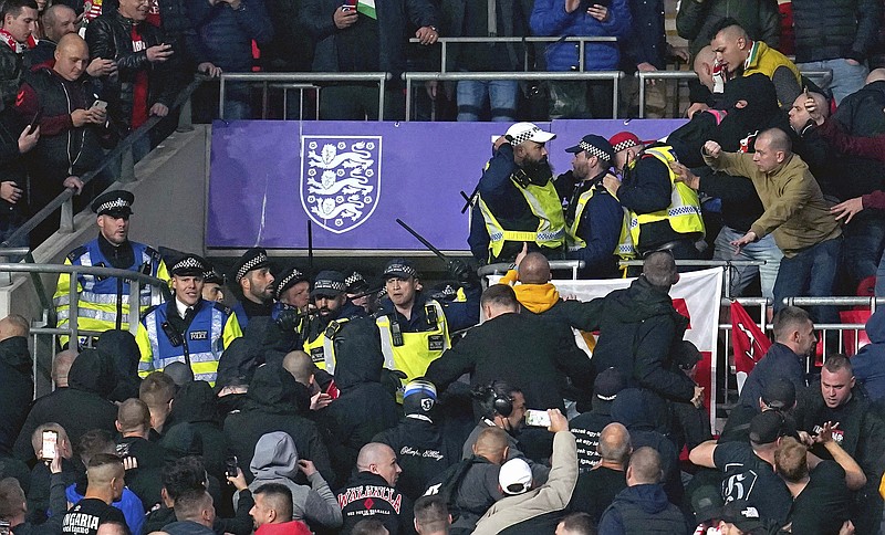 Hungary fans clash with police officers in the stands during the World Cup group I Qualifying soccer match between England and Hungary at Wembley Stadium, London, Tuesday, Oct. 12, 2021. Hungary supporters have clashed with police during the start of a World Cup qualifier against England at Wembley Stadium. Disorder by Hungary fans &#x2014; including racism &#x2014; during the home match against England in Budapest last month led to Hungary having to play Saturday's game against Albania in an empty stadium. (Nick Potts/PA via AP)