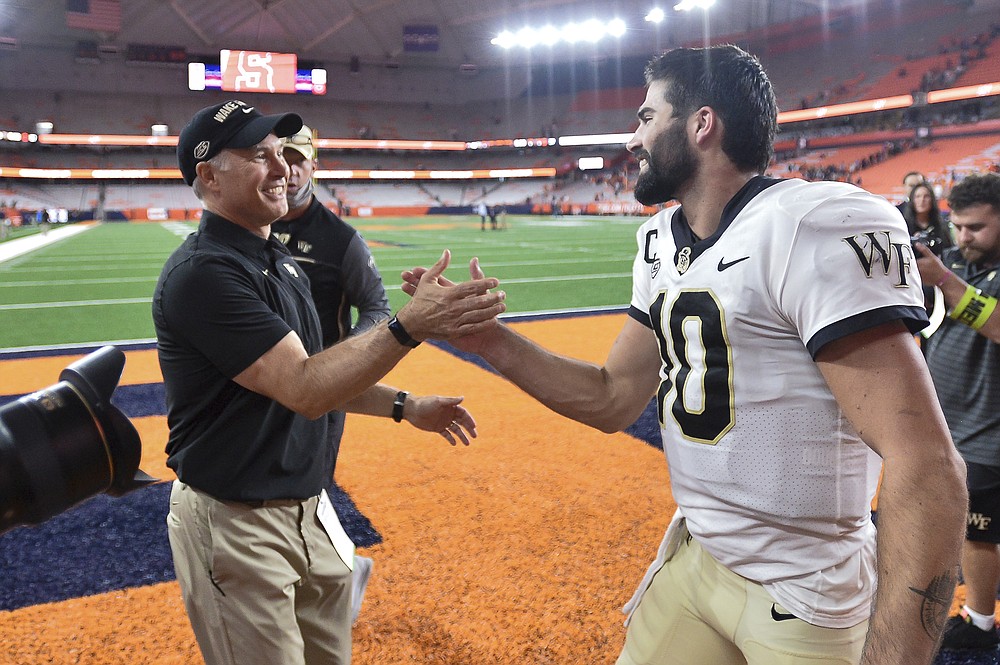 Wake Forest head coach Dave Clawson, left, celebrates with quarterback Sam Hartman after a 40-37 overtime win against Syracuse in an NCAA college football game in Syracuse, N.Y., Saturday, Oct. 9, 2021. (AP Photo/Adrian Kraus)