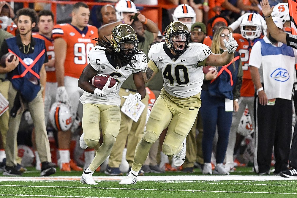 Wake Forest defensive back Ja'Sir Taylor, left, celebrates with defensive lineman Rondell Bothroyd (40) after recovering a fumble by Syracuse running back Cooper Lutz during the second half of an NCAA college football game in Syracuse, N.Y., Saturday, Oct. 9, 2021. (AP Photo/Adrian Kraus)