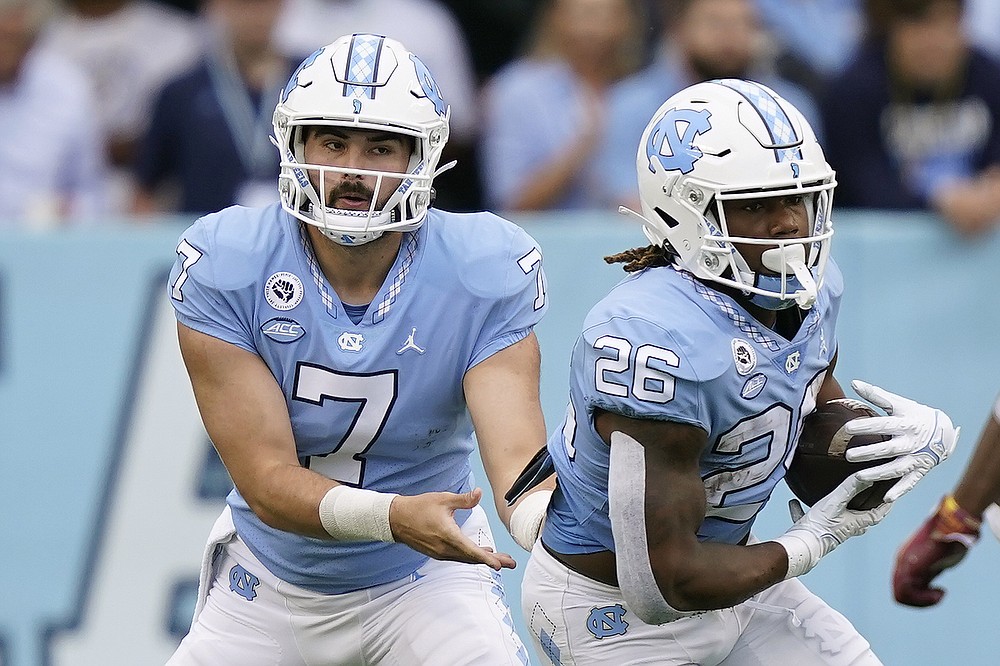 North Carolina quarterback Sam Howell (7) hands off to running back D.J. Jones (26) during the first half of an NCAA college football game against Florida State in Chapel Hill, N.C., Saturday, Oct. 9, 2021. (AP Photo/Gerry Broome)
