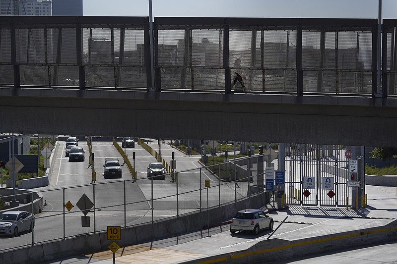 A few cars make their way north to cross into the United States from Tijuana, Mexico, Wednesday, Oct. 13, 2021, at the San Ysidro Port of Entry in San Diego. Beleaguered business owners and families separated by COVID-19 restrictions rejoiced Wednesday after the U.S. said it will reopen its land borders to nonessential travel next month, ending a 19-month freeze. (AP Photo/Gregory Bull)