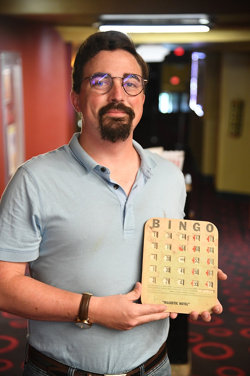 Michael Schwarz, director of "Forever Majestic," holds a bingo card from the hotel while standing in the lobby of the Malco Theatre. - Photo by Tanner Newton of The Sentinel-Record