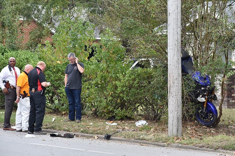 Pine Bluff Police investigators talk with a man about a motorcycle ending up in a bush at 4118 W. 28th Ave., across from the south side of Super 1 Foods on Camden Road, on Thursday, Oct. 14, 2021. (Pine Bluff Commercial/I.C. Murrell)