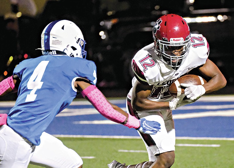 Liberty-Eylau Leopards running back Marquarius Price (12) looks for a path around Spring Hill Panthers defender Favour Otujor (4)  on Friday at Panther Stadium in Longview, Texas. The Leopards came from behind for a 21-15 victory. (Michael Cavazos/Longview News-Journal)