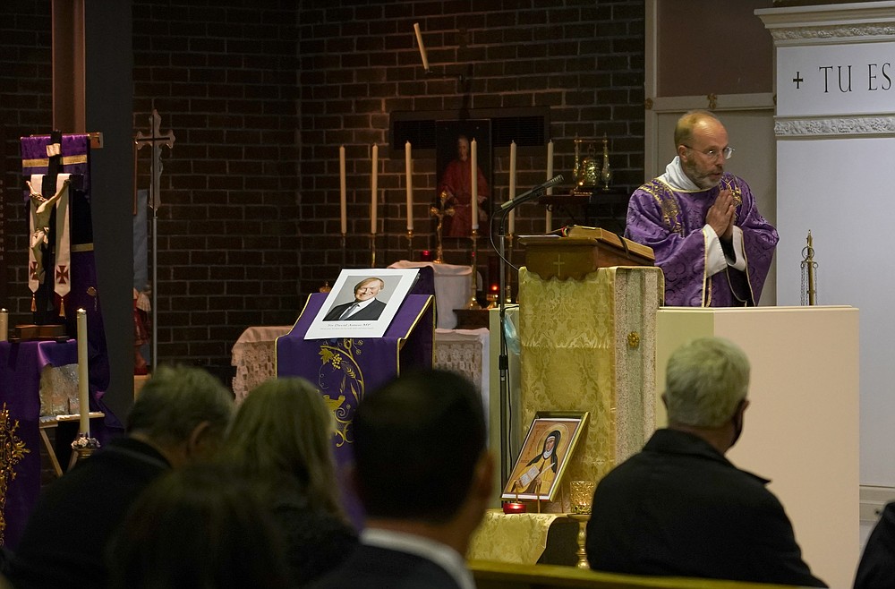 An image of murdered British Conservative lawmaker David Amess is displayed near the altar in St Peters Catholic Church before a vigil in Leigh-on-Sea, Essex, England, Friday, Oct. 15, 2021. Amess died after being stabbed earlier Friday during a meeting with constituents at another nearby church in eastern England. Police gave no immediate details on the motive for the killing of 69-year-old Conservative lawmaker Amess and did not identify the suspect, who was being held on suspicion of murder. (AP Photo/Alberto Pezzali)