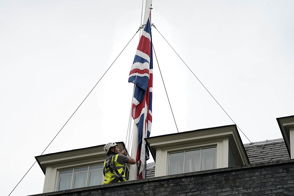 The Union flags above Downing Street have been lowered to half mast to honor British Conservative lawmaker David Amess, in London, Friday, Oct. 15, 2021. British Conservative lawmaker David Amess has died after being stabbed Friday during a meeting with constituents at a church in eastern England. A 25-year-old man has been arrested. (Aaron Chown/PA via AP)