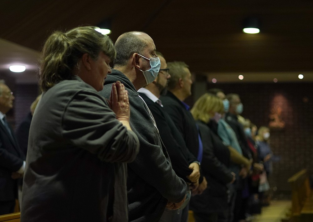 People attend a vigil to murdered British Conservative lawmaker David Amess in St Peters Catholic Church in Leigh-on-Sea, Essex, England, Friday, Oct. 15, 2021. Amess died after being stabbed earlier Friday during a meeting with constituents at another nearby church in eastern England. Police gave no immediate details on the motive for the killing of 69-year-old Conservative lawmaker Amess and did not identify the suspect, who was being held on suspicion of murder. (AP Photo/Alberto Pezzali)