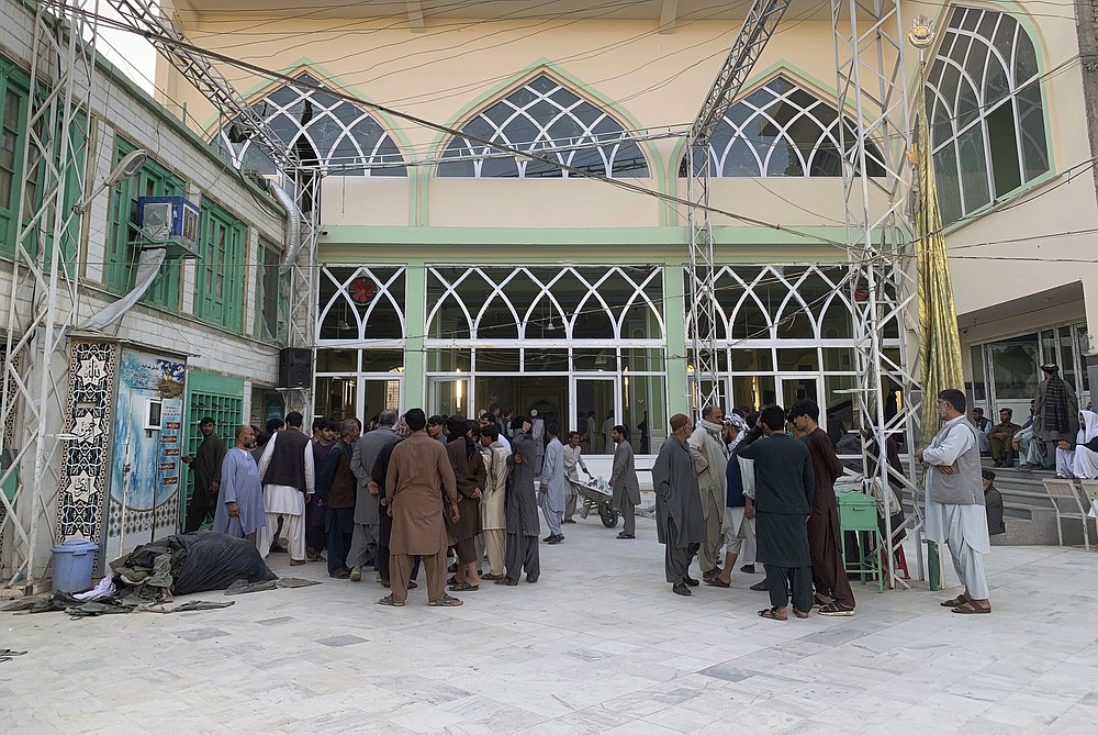 People inspect the inside of a mosque following a suicide bombers attack in the city of Kandahar, southwest Afghanistan, Friday, Oct. 15, 2021. Suicide bombers attacked a Shiite mosque in southern Afghanistan that was packed with worshippers attending Friday prayers, killing several people and wounding others, according to a hospital official and a witness. (AP Photo/Sidiqullah Khan)