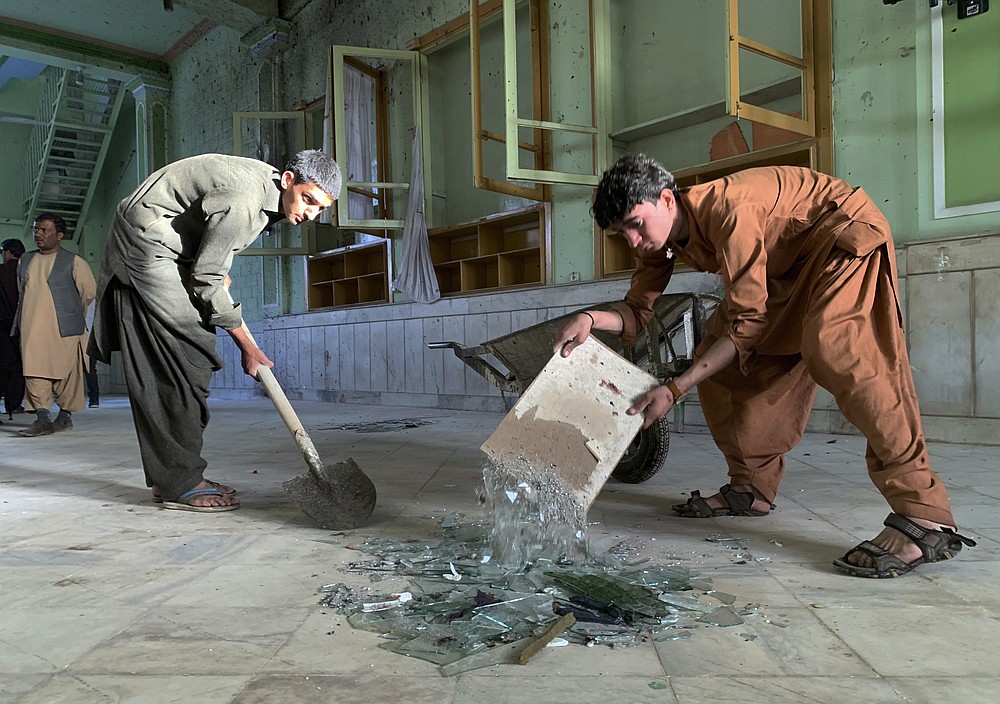 People inspect the inside of a mosque following a suicide bombers attack in the city of Kandahar, southwest Afghanistan, Friday, Oct. 15, 2021. Suicide bombers attacked a Shiite mosque in southern Afghanistan that was packed with worshippers attending Friday prayers, killing several people and wounding others, according to a hospital official and a witness. (AP Photo/Sidiqullah Khan)