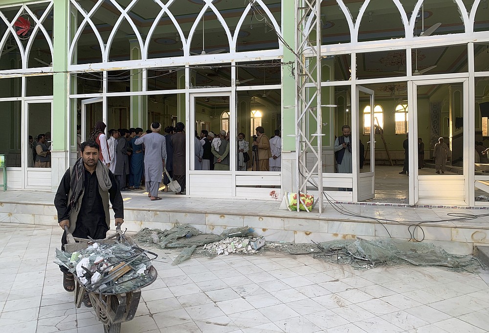 People view the damage inside of a mosque following a suicide bombers attack in the city of Kandahar, southwest Afghanistan, Friday, Oct. 15, 2021. Suicide bombers attacked a Shiite mosque in southern Afghanistan that was packed with worshippers attending Friday prayers, killing several people and wounding others, according to a hospital official and a witness. (AP Photo/Sidiqullah Khan)