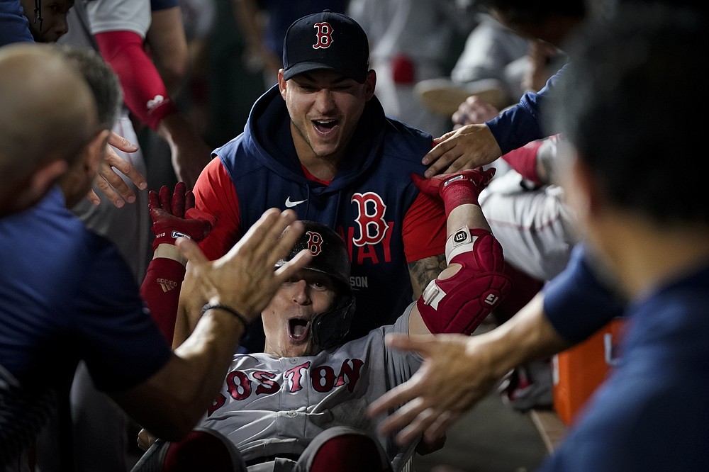 Boston Red Sox's Enrique Hernandez celebrates in the dugout after a home run against the Houston Astros during the third inning in Game 1 of baseball's American League Championship Series Friday, Oct. 15, 2021, in Houston. (AP Photo/David J. Phillip)