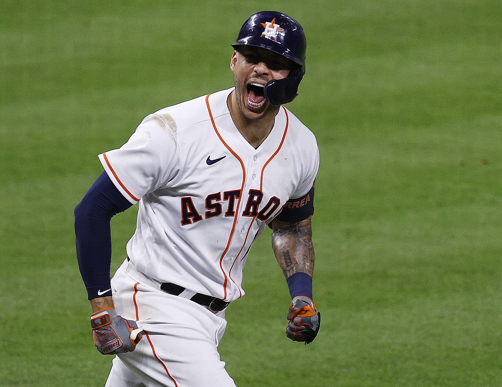 Houston Astros' Carlos Correa screams toward his dugout after hitting a go-ahead solo home run off Boston Red Sox relief pitcher Hansel Robles in the bottom of the seventh inning of Game 1 of baseball's American League Championship Series Friday, Oct. 15, 2021, in Houston. (Kevin M. Cox/The Galveston County Daily News via AP)