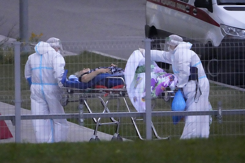 Medical workers carry a patient suspected of having coronavirus on a stretcher at a hospital in Kommunarka, outside Moscow, Russia, Saturday, Oct. 16, 2021. Russia's daily death toll from COVID-19 has exceeded 1000 for the first time as the country faces a sustained wave of rising infections. (AP Photo/Alexander Zemlianichenko)