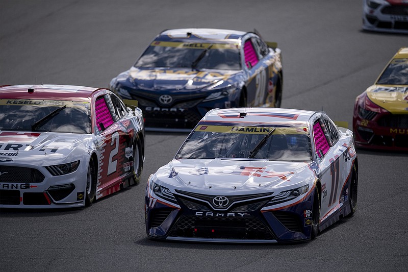 Denny Hamlin (11) leads a pack of cars during a NASCAR Cup Series auto racing race at Charlotte Motor Speedway, Sunday, Oct. 10, 2021, in Concord, N.C. (AP Photo/Matt Kelley)