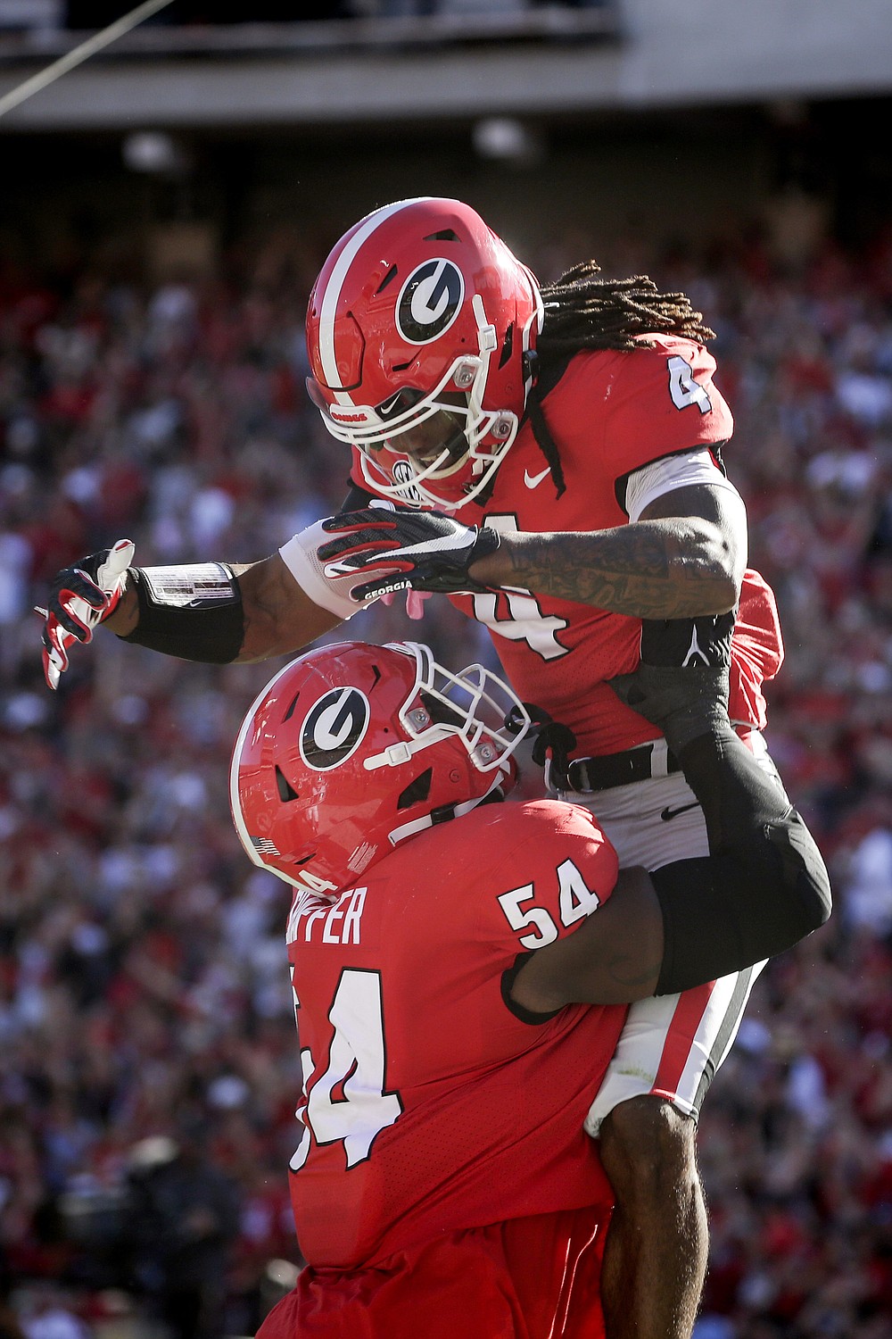 Georgia running back James Cook (4) celebrates with offensive lineman Justin Shaffer (54) after a touchdown against Kentucky during the first half of an NCAA college football game, Saturday, Oct. 16, 2021 in Athens, Ga. (AP Photo/Butch Dill)