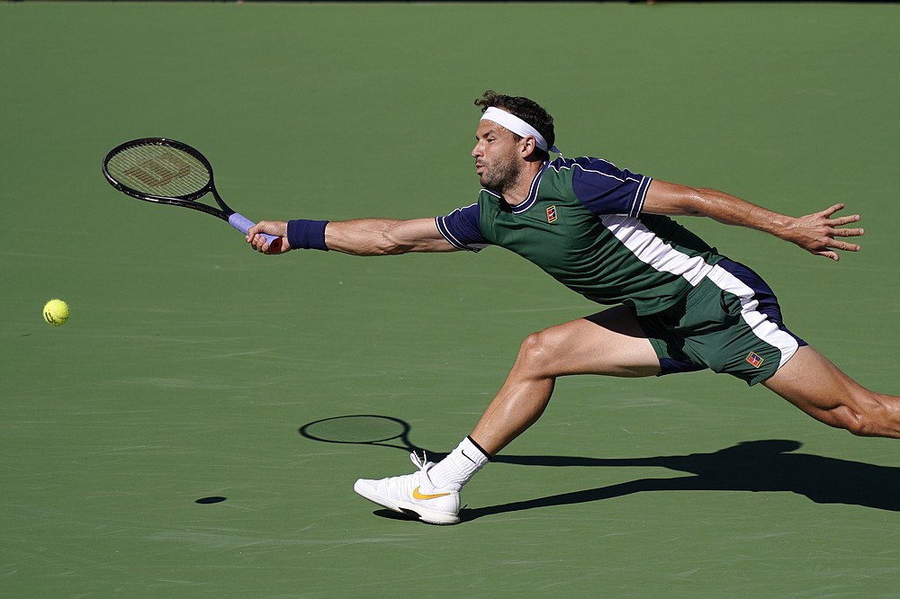 Grigor Dimitrov, of Bulgaria, returns to Cameron Norrie, of Britain, in a semifinal match at the BNP Paribas Open tennis tournament, Saturday, Oct. 16, 2021, in Indian Wells, Calif. (AP Photo/Mark J. Terrill)