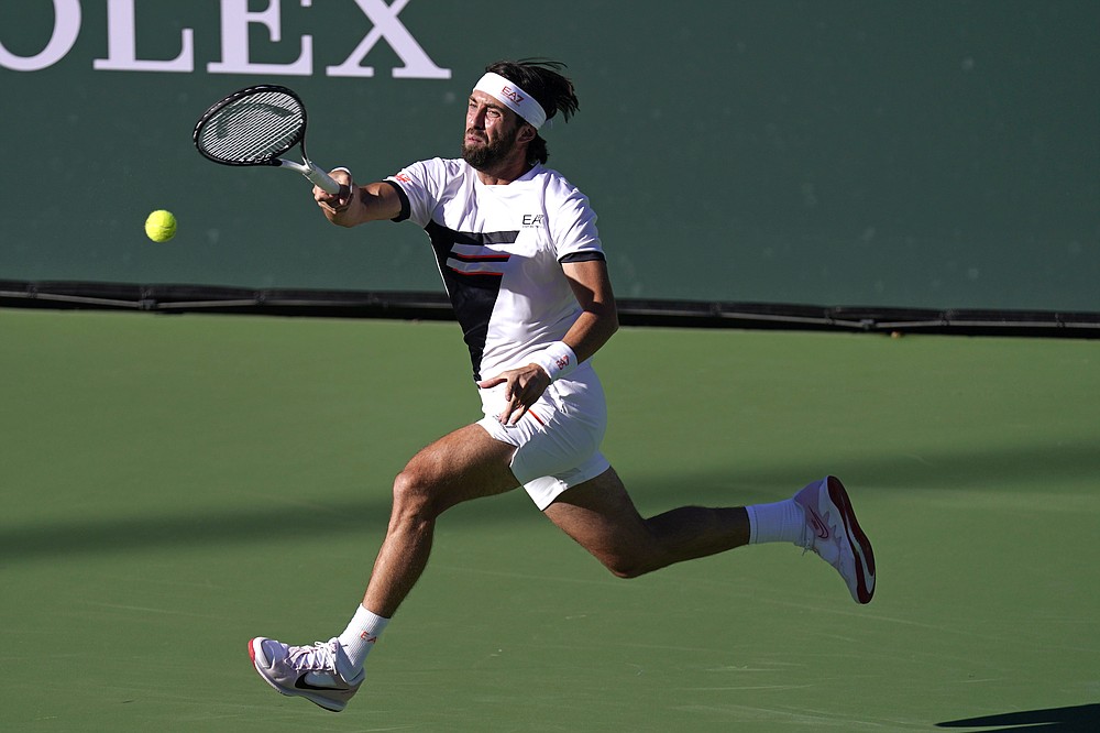 Nikoloz Basilashvili, of Georgia, returns to Taylor Fritz, of the United States, in a semifinal match at the BNP Paribas Open tennis tournament Saturday, Oct. 16, 2021, in Indian Wells, Calif. (AP Photo/Mark J. Terrill)