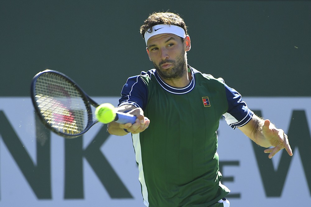 Grigor Dimitrov, of Bulgaria, hits a forehand to Cameron Norrie, of Britain, during a semifinal at the BNP Paribas Open tennis tournament Saturday, Oct. 16, 2021, in Indian Wells, Calif. (AP Photo/John McCoy)